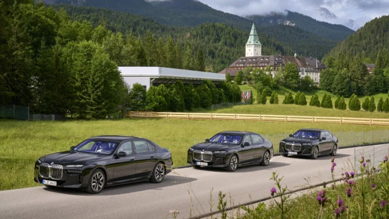 A line of black BMW 7-Series cars wait to pick up dignitaries at the recent G7 summit.