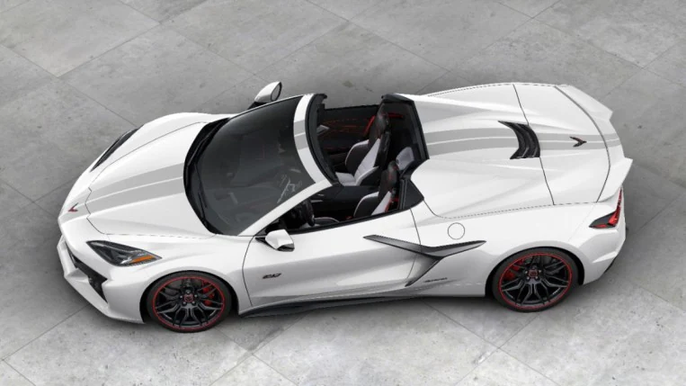 The 2023 Corvette Z06 70th anniversary edition convertible sits parked on Concrete. The car is white, with gray stripes. We see it from an overhead angle.