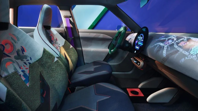 The cabin of the Mini Aceman concept. Its seats are upholstered in many fabrics cut at odd angles,including one in blue denim and one with neon X's and O's. The dashboard has moving multicolored words projected onto it.