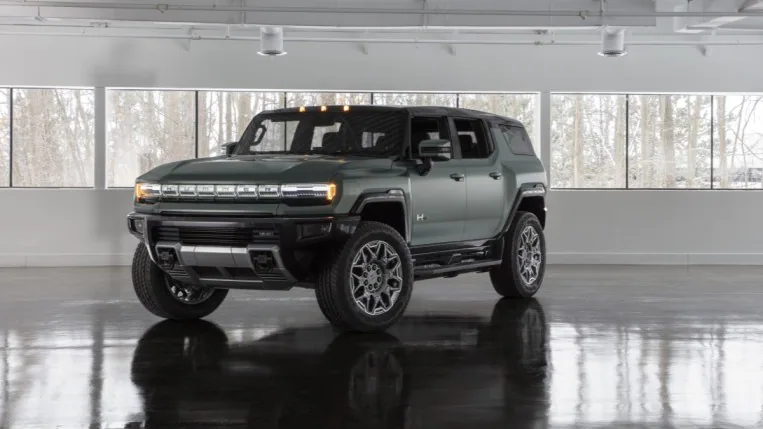 The GMC Hummer electric SUV in green. We see it from a front quarter angle, facing slightly to our left.