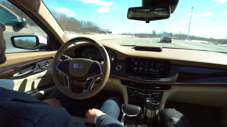 The interior of the 2018 Cadillac CT5 with Super Cruise engaged. The driver's hands are resting in their lap.
