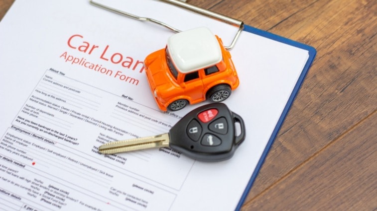 Car loan application and car keys on a desk